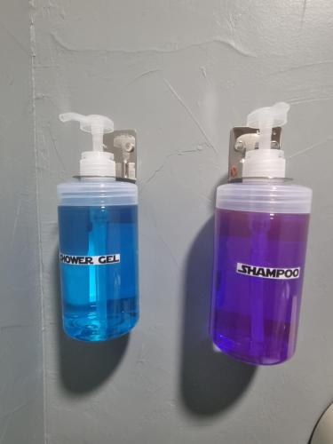two bottles of water are hanging on a wall at Met A Space Pod @Phrom Phong in Bangkok