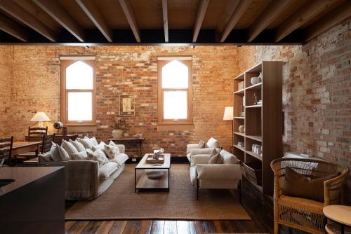 a living room filled with furniture and a brick wall at The Rox Hobart in Hobart