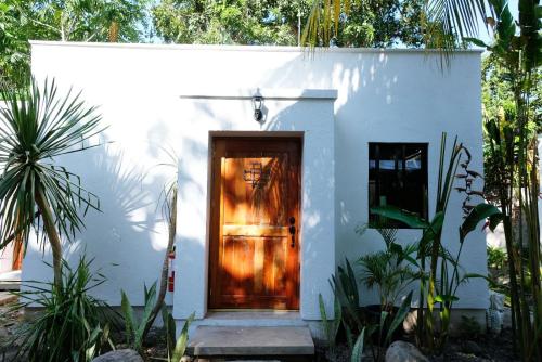 a small white house with a wooden door at Mad Monkey Dumaguete in Dumaguete