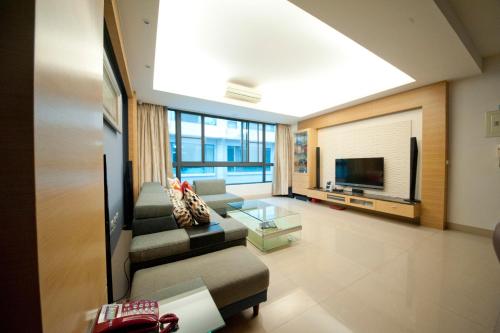 sala de estar con sofá y TV en Ken's Joy Inn, en Kaohsiung