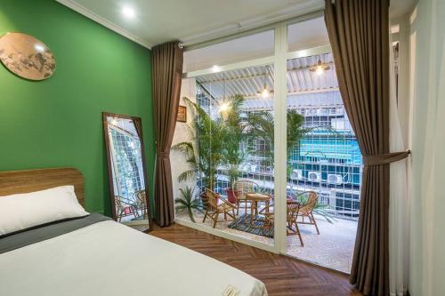 a bedroom with a bed and a window with a table and chairs at Homestay Hang Tre 5min to Bar street in Hanoi