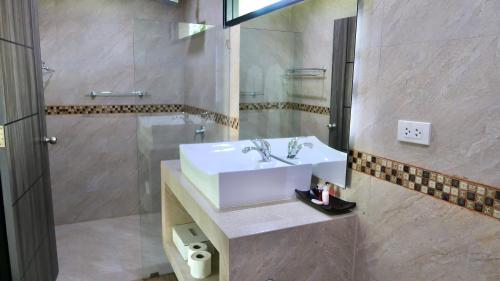 W łazience znajduje się biała umywalka i prysznic. w obiekcie Jasmine Village w mieście Rawai Beach