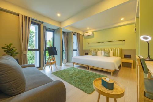 Chamemon Bed Phuket Town في فوكيت تاون: غرفه فندقيه بسرير واريكه