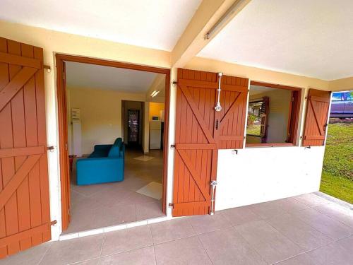 una puerta abierta a una casa con dos puertas de madera en Paisible T2 sur Sainte-Marie en Sainte-Marie