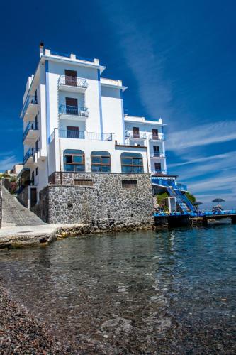 a white building sitting next to the water at Hotel Rocce Azzurre in Lipari