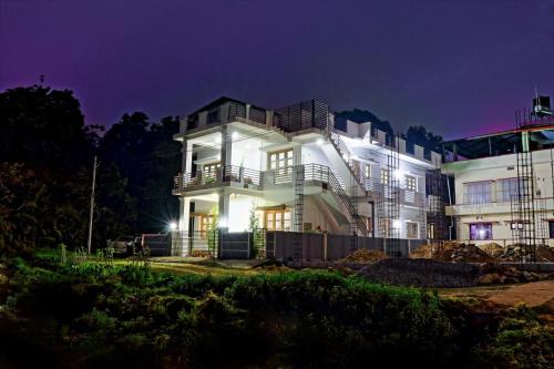 a large white house at night at Coorg Rahul Villa- 3 Deluxe Bedrooms in Madikeri