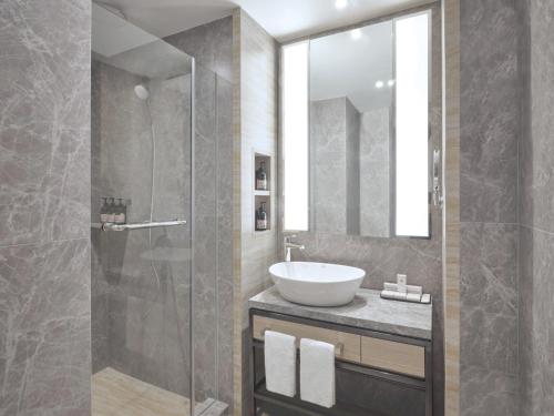 a bathroom with a sink and a glass shower at Grand Copthorne Waterfront in Singapore