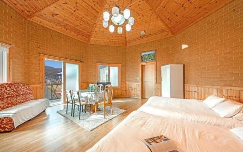 a large room with a bed and a table at Sunbeach Pension in Geoje 