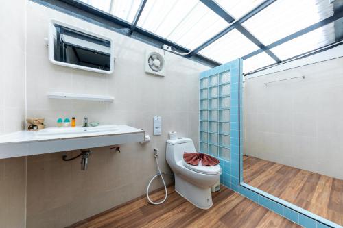 a bathroom with a toilet and a sink and a window at Phi Phi Long Beach Bungalow ( Had Yao) in Phi Phi Don