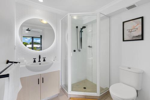 a white bathroom with a sink and a shower at The Loft Cairns in Cairns