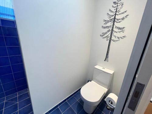 a bathroom with a toilet with a tree on the wall at Luxury Lake View House in Lake Tekapo