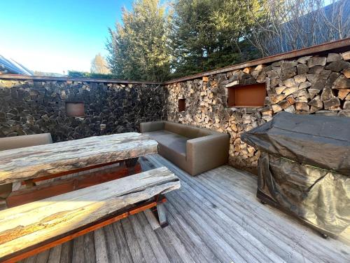 a patio with a bench and a stone wall at Luxury Lake View House in Lake Tekapo