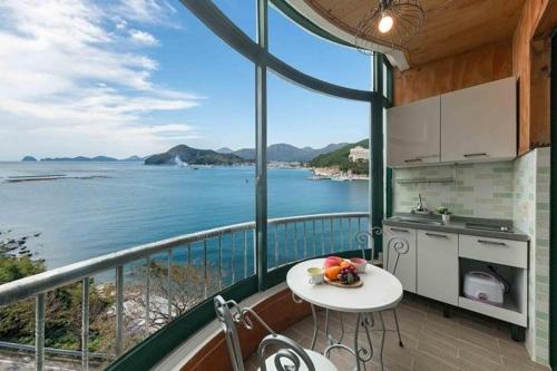 a kitchen with a view of the ocean from a balcony at Sunbeach Pension in Geoje 