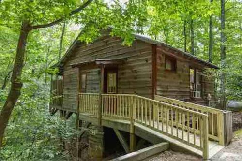 a log cabin in the middle of the woods at Cozy Cabin: River View with Hot Tub in Dahlonega