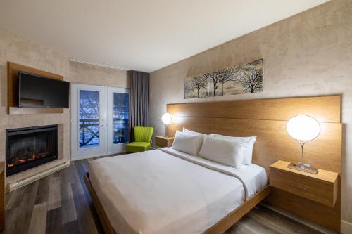 a hotel room with a bed and a fireplace at Hotel Chateau Bromont in Bromont