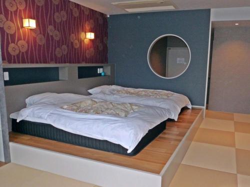 um quarto com 2 camas e um espelho na parede em Hotel Heian em Fuefuki