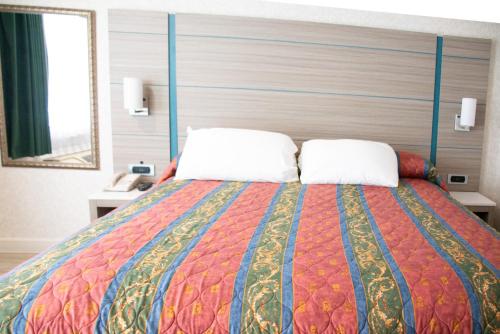 a bedroom with a large bed with two pillows at Discovery Inn in Hayward