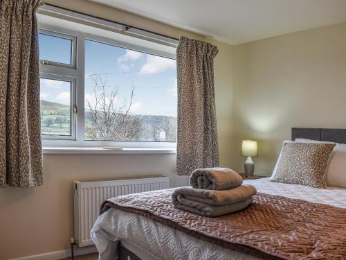 a bedroom with a bed with a large window at Low View in Chelmorton