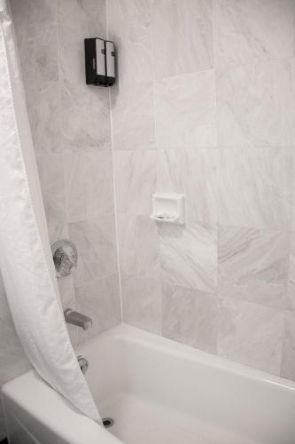 a bathroom with a white tub and a toilet at Discovery Inn in Hayward