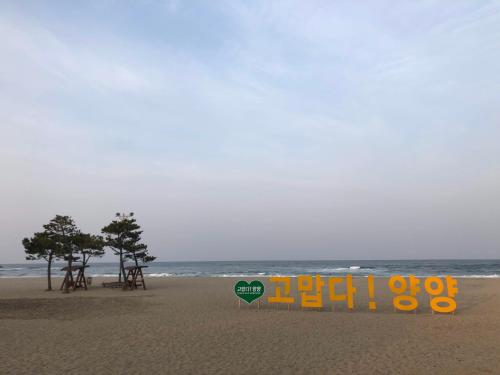 a sign in the sand on a beach at Yangyang Naksan Bamgol Land in Yangyang