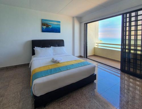 um quarto com uma cama grande e uma janela grande em 'Sunny seaview condo' at Regency by Shine Stay em Porto Dickson