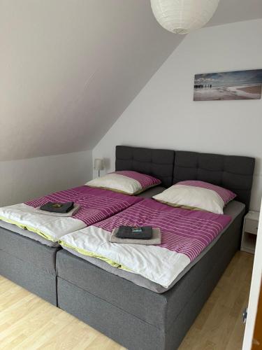 Una cama con sábanas moradas y dos libros. en Sonnenschein en Uelzen