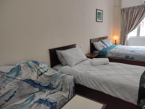 a bedroom with two beds and a couch in it at Sofea Inn Bukit Merah - Laketown D6529 in Kampong Selemat