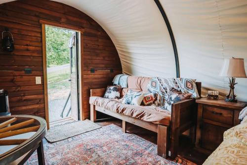 ein Wohnzimmer mit einem Sofa und einem Fenster in der Unterkunft Heated & AC Full Bathroom Covered Wagon in Penn Yan