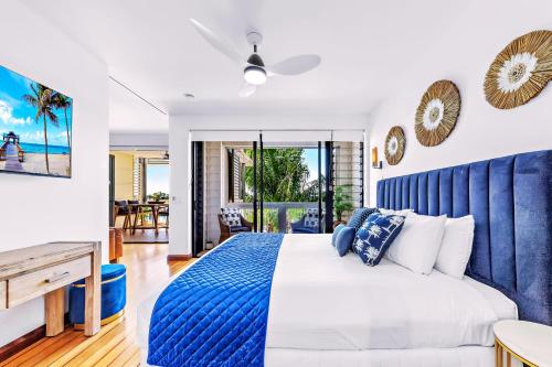 a bedroom with a bed with a blue headboard at Absolute Luxury Marina Lifestyle at The Port of Airlie Beach in Airlie Beach