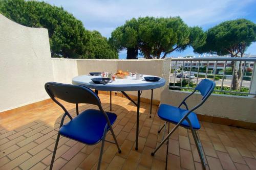 une table et deux chaises assises sur un balcon dans l'établissement Le saint Louis - Studio terrasse proche de la plage, au Grau-du-Roi