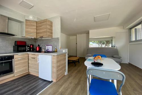 une cuisine avec une table et des chaises dans une pièce dans l'établissement Le saint Louis - Studio terrasse proche de la plage, au Grau-du-Roi