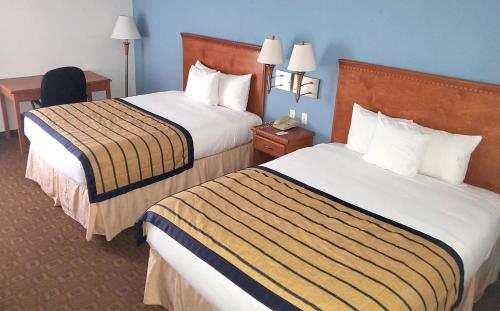 a hotel room with two beds and a desk at Coratel Inn & Suites by Jasper New Braunfels IH-35 EXT 189 in New Braunfels