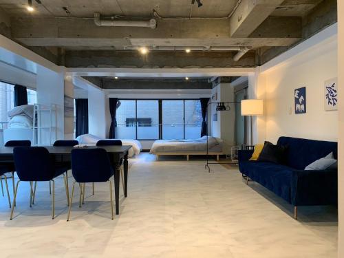 a living room with a blue couch and a table at Spacious studio(62m2) in western Shinjuku in Tokyo