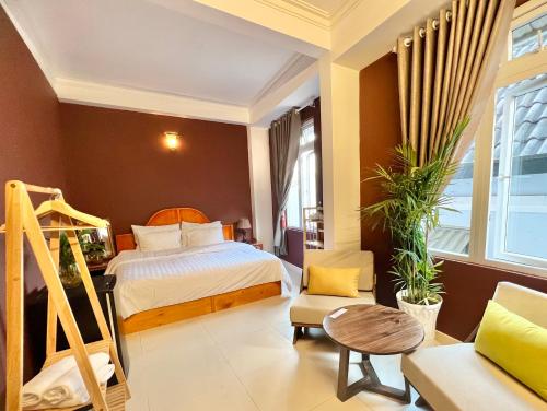 - une chambre avec un lit, une chaise et une table dans l'établissement Nhà An Đà Lạt, à Đà Lạt