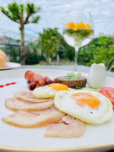 バオロクにあるSunflower Hotel & Resortの卵、肉、ワイン一杯の盛り合わせ
