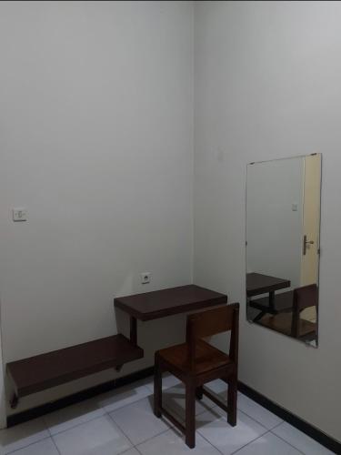 a room with a mirror and a table and a chair at Penginapan Sriwijaya Semarang in Jomblang