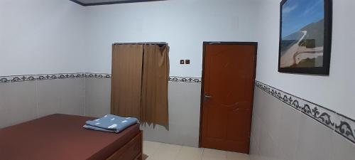 um quarto com uma casa de banho com uma porta e uma mesa em Zian bogos homestay em Ekas