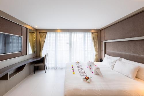 una camera d'albergo con un grande letto e una TV di Centara Azure Hotel Pattaya a Centro di Pattaya