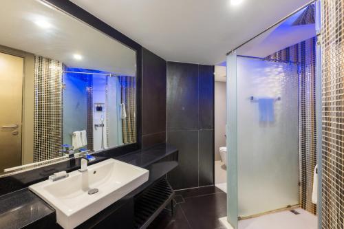 bagno con lavandino e doccia in vetro di Centara Azure Hotel Pattaya a Centro di Pattaya