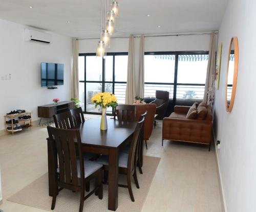 a dining room and living room with a table and chairs at Luxury & Comfort, with Pool and Ocean Views in Bijilo