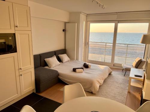 um quarto com uma cama e vista para o oceano em Zeedijk family apartment em Knokke-Heist