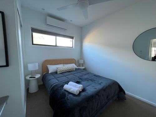 a bedroom with a bed with two towels on it at Bundalong Villas in Bundalong