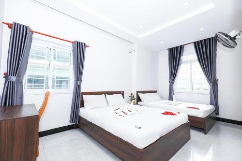 a bedroom with two beds and a desk at Ciao Hồng Phúc Hotel in Quy Nhon