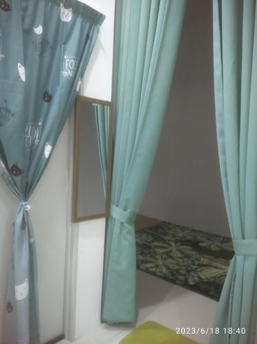 a room with blue curtains and a mirror at Rumah Lunas in Lunas