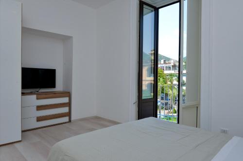 a bedroom with a bed and a flat screen tv at L'Aurora Azzurra -Luxury Suites in Piano di Sorrento