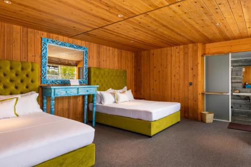 a bedroom with two beds and a mirror and a table at Elephyard Retreat in Mahiyangana