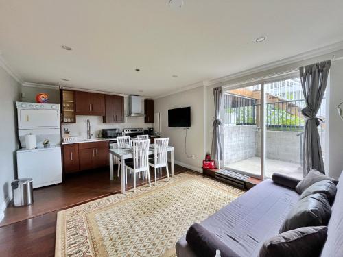 a living room with a couch and a kitchen at Coze home in Vancouver near YVR in Vancouver