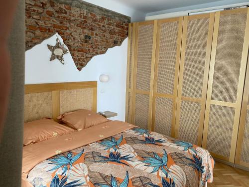 a bedroom with a bed and a brick wall at Sweet cozy Ultracentral in Craiova