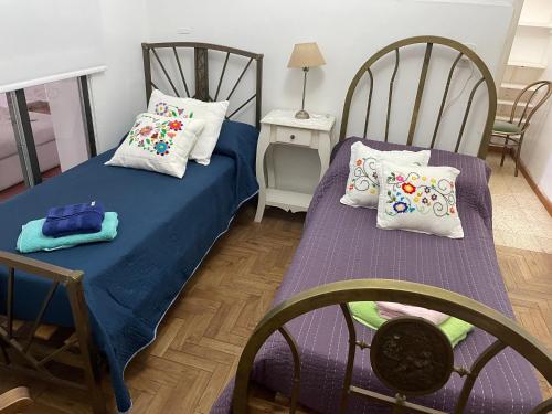 - une chambre avec 2 lits avec des oreillers et une table dans l'établissement Casa Evaluna, à San Pedro