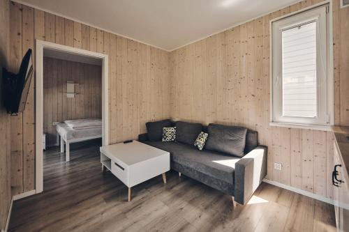 a living room with a couch and a window at Holiday Siesta Domki in Rewal
